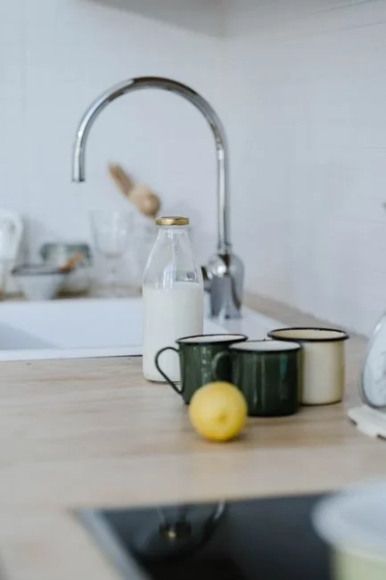 Homme barbu méconnaissable portant des gants en latex jaunes et essuyant le miroir avec une serviette dans la salle de bain à la maison